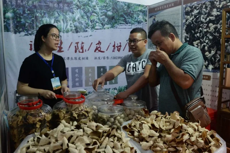 customers smelling aged xinhui chenpi peel at a tea market booth