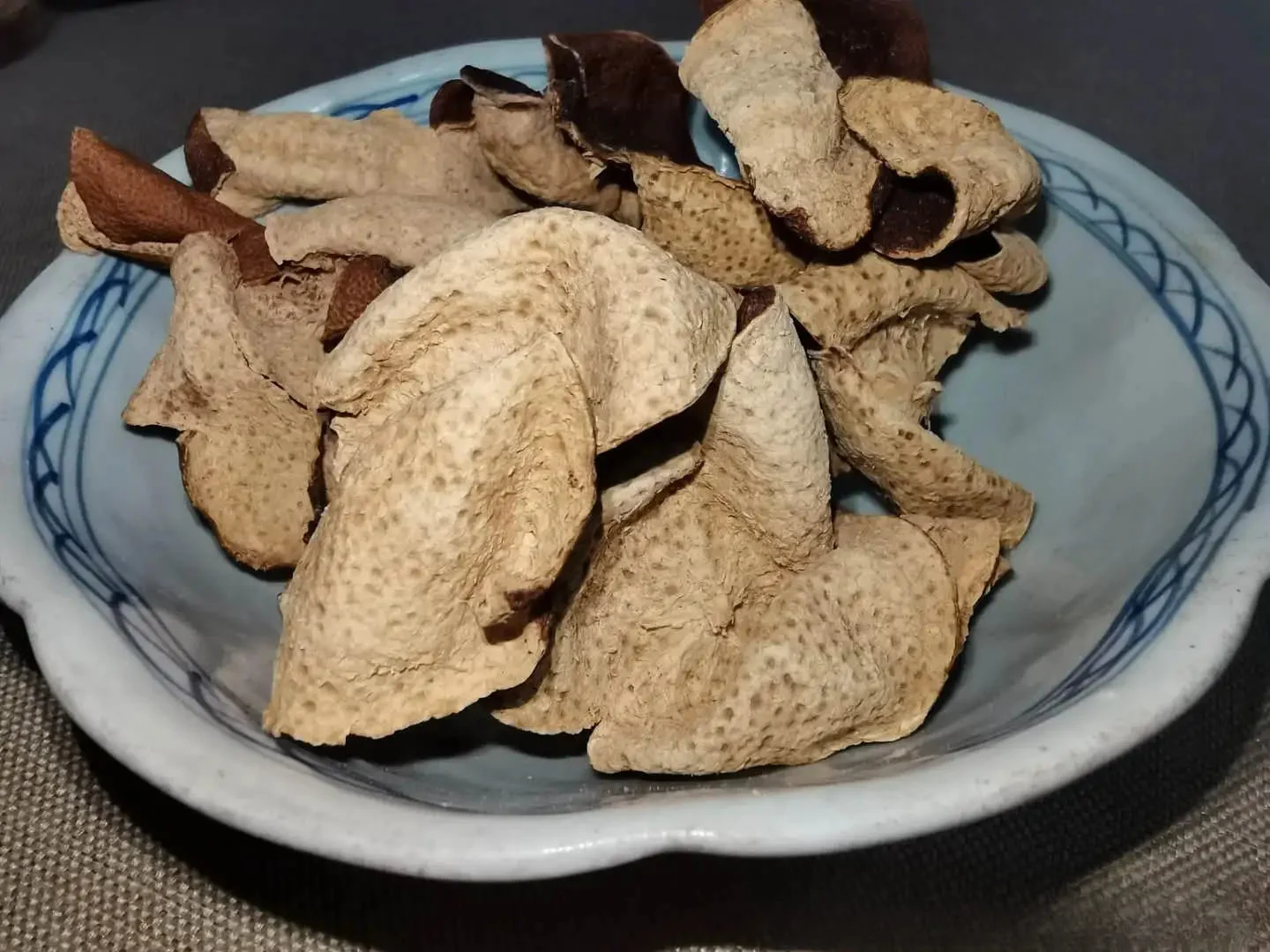 sun-dried aged xinhui chenpi peels in a traditional ceramic bowl